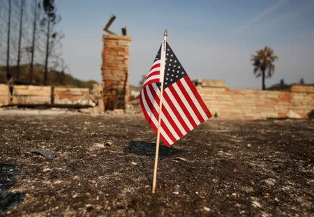 An American flag stands in front of a home destroyed after a wildfire tore through Santa Rosa, California, U.S., October 15, 2017. REUTERS/Jim Urquhart