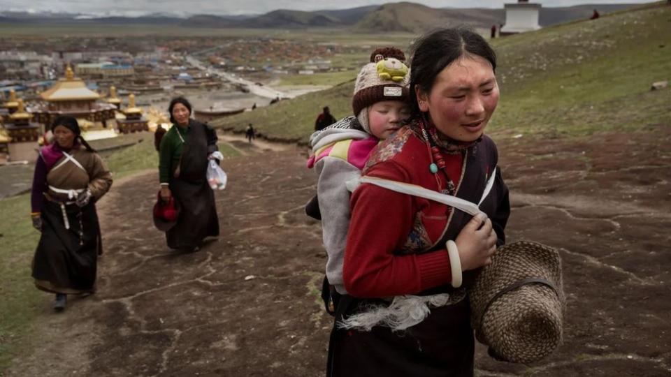 Madres orientales cargan a sus bebés en la espalda.