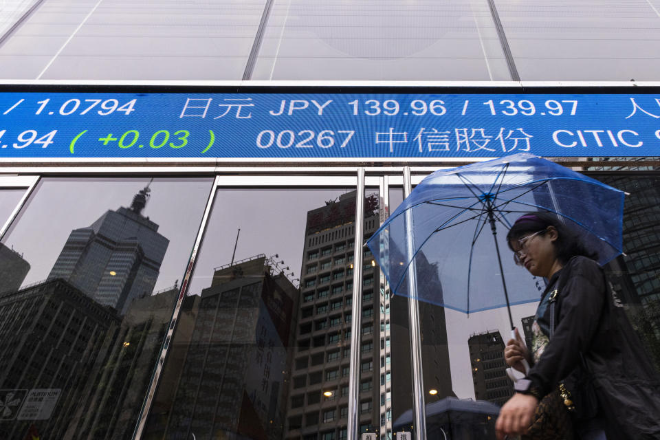 A pedestrian passes by the Hong Kong Stock Exchange electronic screen in Hong Kong, Wednesday, June 14, 2023. Asian stock markets followed Wall Street higher on Wednesday after a cooler reading on U.S. inflation fueled hopes the Federal Reserve will postpone a possible interest rate hike. (AP Photo/Louise Delmotte)