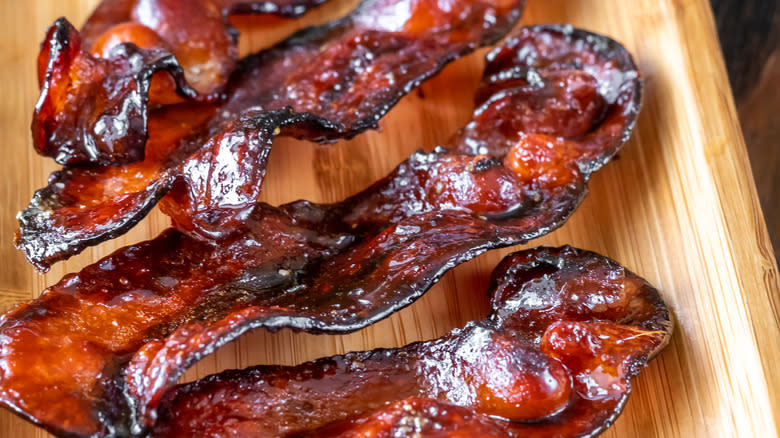 Close up of candied bacon on wood tray