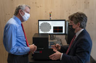 FILE - In this April 28, 2021 file photo, New York Mayor Bill de Blasio, left, speaks with Matthew Putman, co-founder and CEO of Nanotronics, during a facility tour before a ribbon-cutting ceremony to mark the opening of a Nanotronics manufacturing center at the Brooklyn Navy Yard in the Brooklyn borough of New York. Putman said he agonized over his decision to impose a vaccine mandate on his more than 100 employees, who have mostly been working onsite throughout the pandemic. As it turned out, nearly all of his workers were already vaccinated, though he dreads the prospect of having to fire any holdouts.(AP Photo/John Minchillo, Pool)