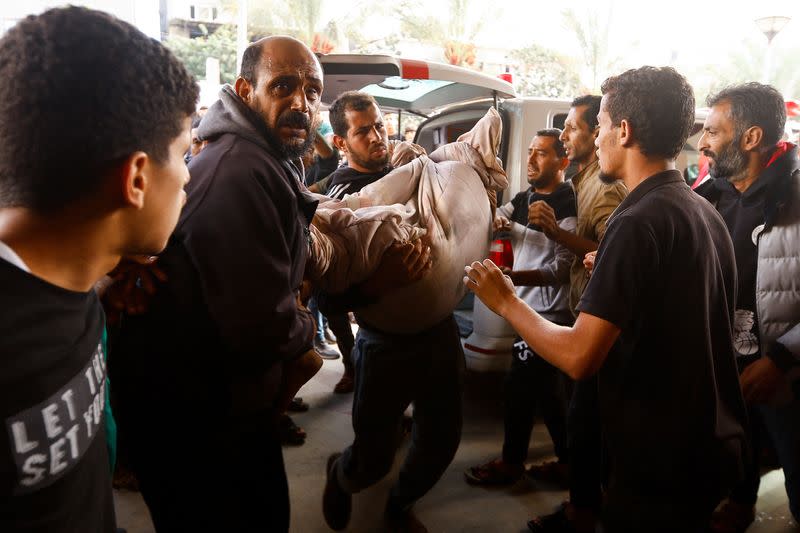 Un hombre palestino sostiene a una víctima mientras ingresa corriendo al hospital, luego de un ataque israelí, en medio del conflicto en curso entre Israel y el grupo islamista palestino Hamás, en Jan Yunis, en el sur de la Franja de Gaza