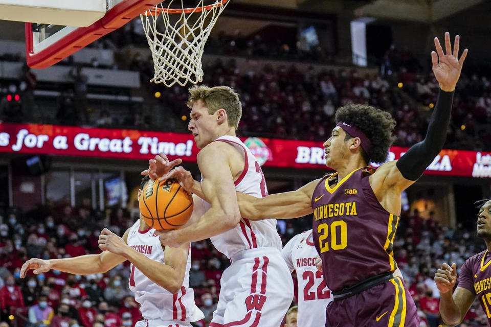 Wisconsin's Ben Carlson grabs a defensive rebound against Minnesota's Eylijah Stephens (20) during the first half of an NCAA college basketball game Sunday, Jan. 30, 2022, in Madison, Wis. (AP Photo/Andy Manis)