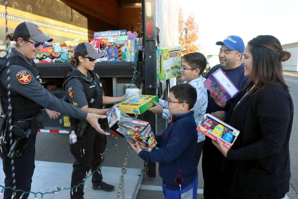 Ofc. Williams and Cpl. Gajardo with the Amarillo Police Department take in toys donated by the Noriega family during the 4th annual Cops for CASA toy drive at Winpark Plaza on Wednesday.
