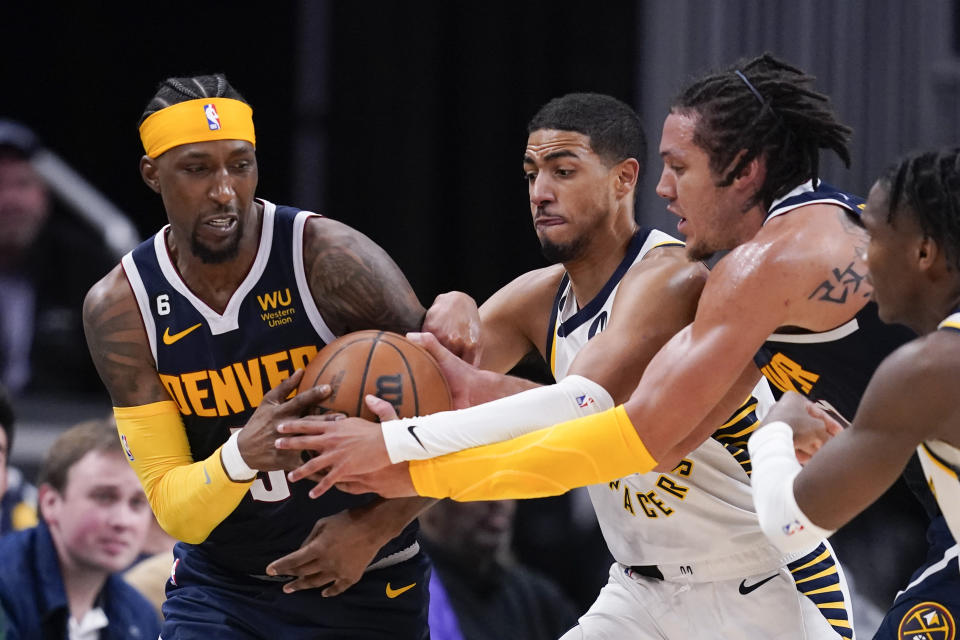 Denver Nuggets' Kentavious Caldwell-Pope, left, Indiana Pacers' Tyrese Haliburton, middle and Denver Nuggets' Aaron Gordon battle for a loose ball during the second half of an NBA basketball game, Wednesday, Nov. 9, 2022, in Indianapolis. Denver won 122-119. (AP Photo/Darron Cummings)