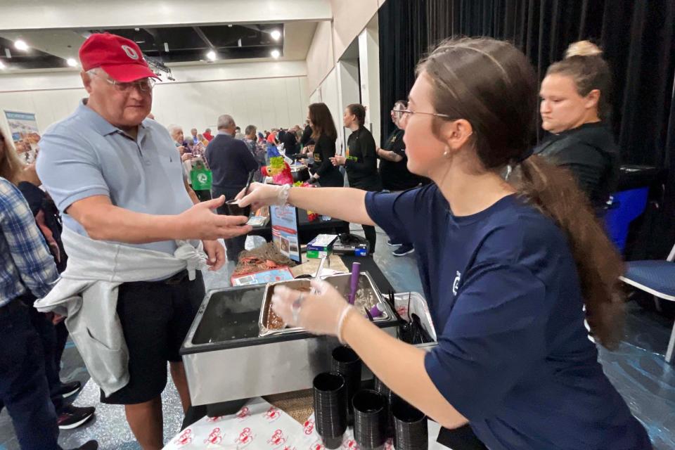 Gabrielle Forbish with The Crab Trap serves up a sampling from the restaurant's menu to visiting snowbird Paul Hinshaw during Thursday's Winter Guest Fest at the Destin-Fort Walton Beach Convention Center.