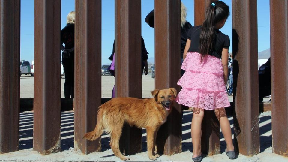 una niña mira en la frontera de México con Estados Unidos.