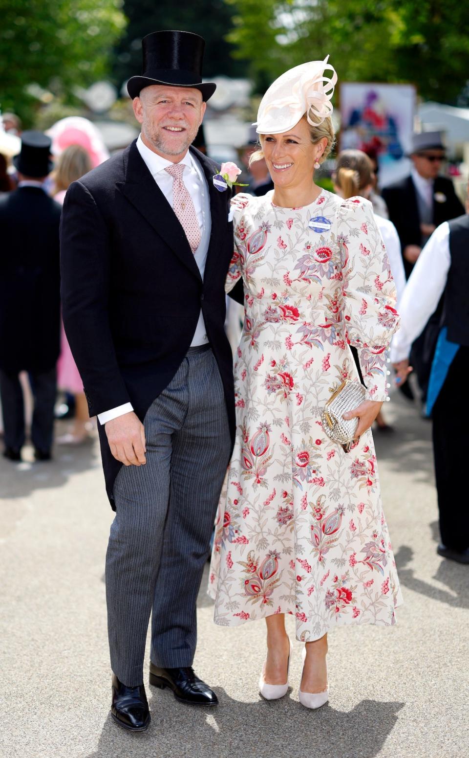 Mike Tindall is wearing a morning suit and tophat, and Zara Tindall is wearing a white and red floral summer dress.