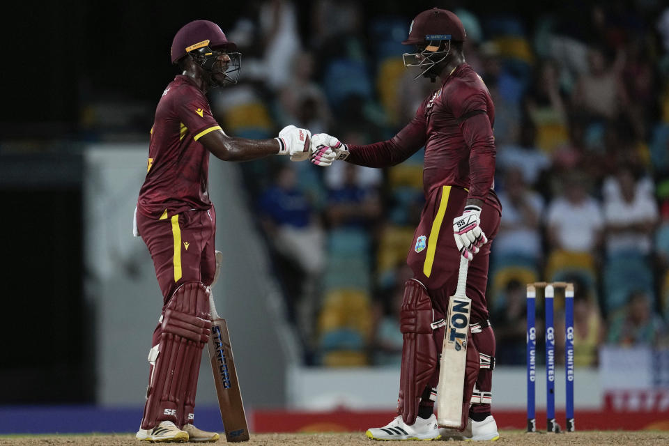 West Indies' Matthew Forde, left, and Romario Shepherd knock gloves during the third ODI cricket match against England at Kensington Oval in Bridgetown, Barbados, Saturday, Dec. 9, 2023. (AP Photo/Ricardo Mazalan)