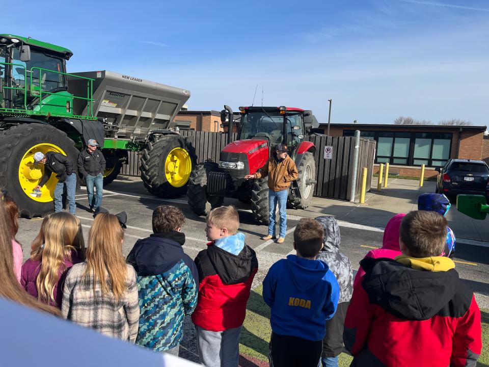 Sunrise Cooperative and Gillmor Farms explain to the third graders in Clyde-Green Springs schools how important fertilizer and tillage are to raising a successful field crop.  Representatives from Sunrise provided this John Deere Fertilizer Applicator for the students to see.