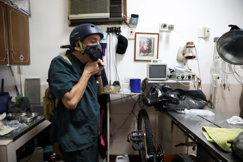 Veterinarian Pedro Villegas puts his helmet after a work shift in Caracas