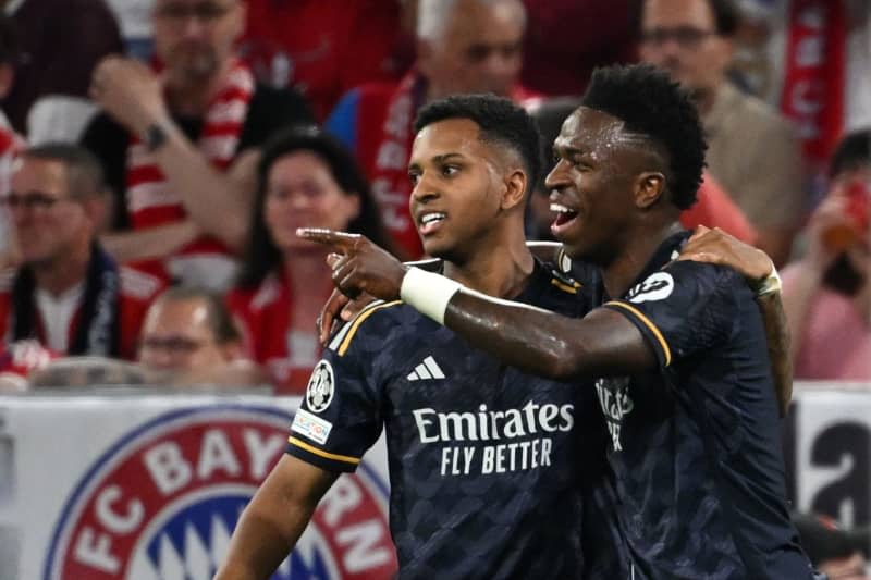 Real Madrid's Vinicius Junior (R) celebrates scoring his side's first goal with teammate Rodrygo during the UEFA Champions League semi-final first leg soccer match between Bayern Munich and Real Madrid at Allianz Arena. Sven Hoppe/dpa