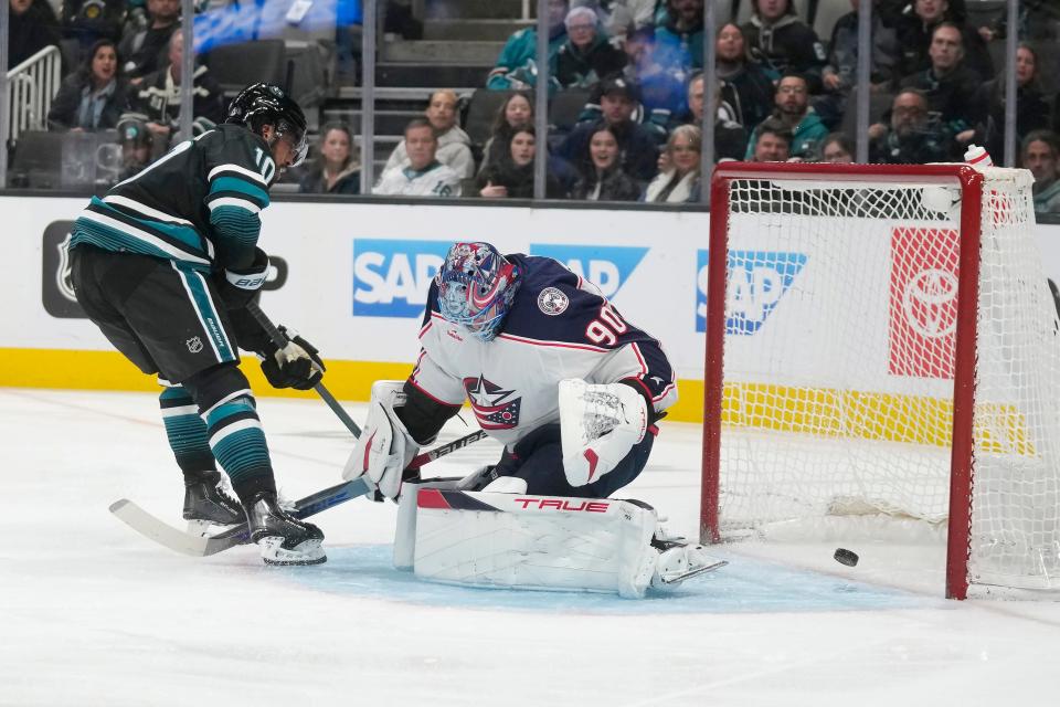 San Jose Sharks left wing Anthony Duclair, left, scores a goal past Columbus Blue Jackets goaltender Elvis Merzlikins during the first period of an NHL hockey game in San Jose, Calif., Saturday, Feb. 17, 2024. (AP Photo/Jeff Chiu)
