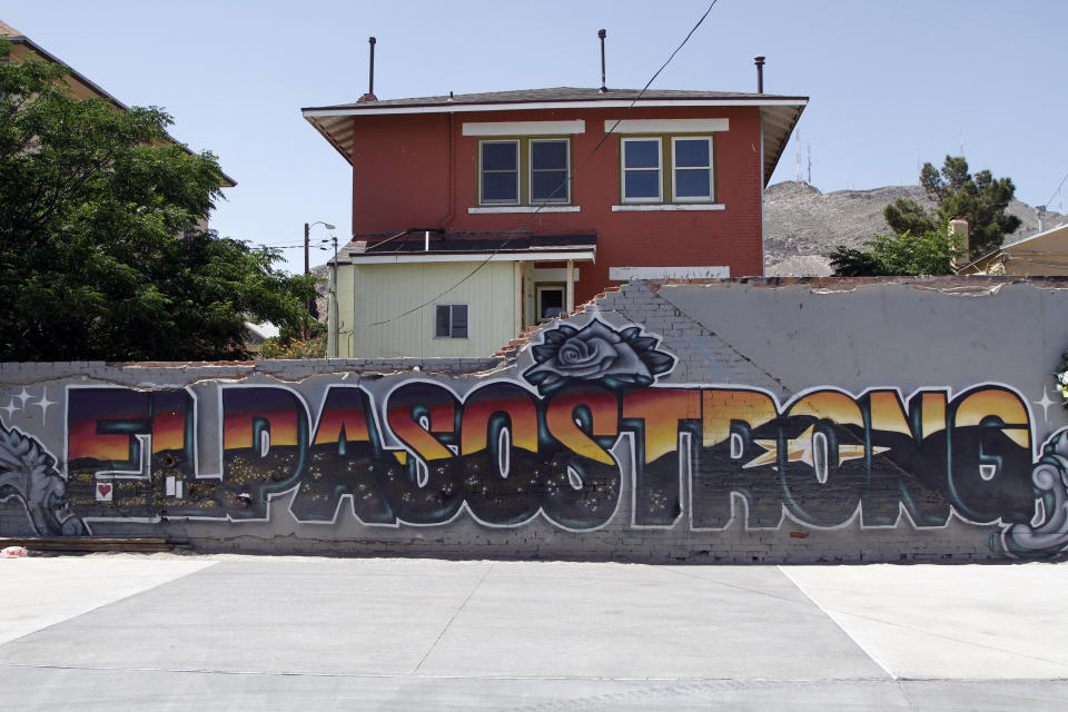 This May 7, 2020 photo shows an "El Paso Strong" mural painted in the wake of the Aug. 3, 2019 shooting by artists Gabe Vasquez and Justin Martinez in El Paso, Texas. The star painted in the mural's letters can be seen at night in the Franklin Mountains in the background.(AP Photo/Cedar Attanasio)