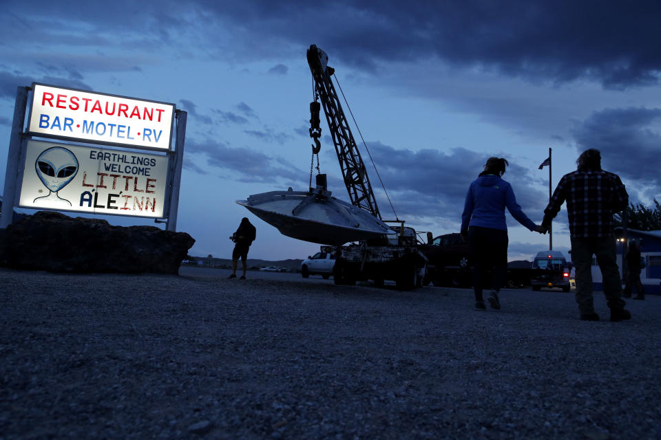 People walk near the Little A'Le'Inn during an event inspired by the "Storm Area 51" internet hoax, Thursday, Sept. 19, 2019, in Rachel, Nev. Hundreds have arrived in the desert after a Facebook post inviting people to "see them aliens" got widespread attention and gave rise to festivals this week. (AP Photo/John Locher)