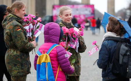Female soldiers of the German Armed Forces (Bundeswehr) distribute flowers to women during the International Women's Day near the Brandenburg Gate in Berlin, Germany, March 8, 2019. REUTERS/Hannibal Hanschke