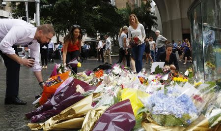 Mourners lay floral tributes to those who died in the Sydney cafe siege, near the site of the incident, in Martin Place December 16, 2014. REUTERS/Jason Reed