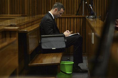 Olympic and Paralympic track star Oscar Pistorius sits beside a green pail in the dock during court proceedings at the North Gauteng High Court in Pretoria March 14, 2014. REUTERS/Phill Magakoe/Pool