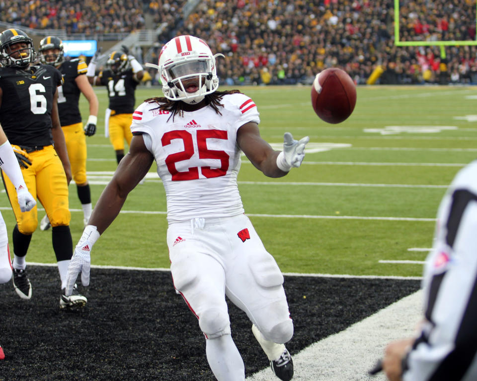 Nov 22, 2014; Iowa City, IA, USA; Wisconsin Badgers running back Melvin Gordon (25) flips the football to the official after scoring against the Iowa Hawkeyes at Kinnick Stadium. Mandatory Credit: Reese Strickland-USA TODAY Sports