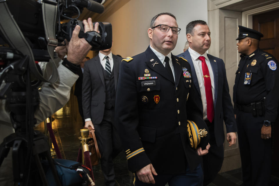 National Security Council aide Lt. Col. Alexander Vindman, left, leaves Capitol Hill as they conclude a public impeachment hearing of President Donald Trump's efforts to tie U.S. aid for Ukraine to investigations of his political opponents, in Washington, Tuesday, Nov. 19, 2019. (AP Photo/Manuel Balce Ceneta)