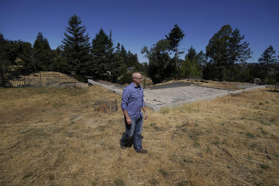 Will Abrams walks on the lot of his family home that was destroyed by wildfires in 2017 while interviewed in Santa Rosa, Calif., Thursday, June 24, 2021. “I have been really disappointed," Abrams said. “The bankruptcy was sold as something that was going to hold PG&E to account, and it was not. Bankruptcy is not a process to reorganize. It is a process to divide up the dollars." (AP Photo/Jeff Chiu)