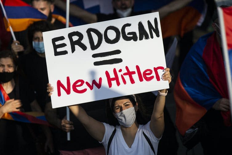 <span class="caption">A protester holds a placard reading ‘Erdogan = New Hitler’ as thousands American-Armenian protesters march in front of the Consulate General of Turkey, demonstrating for Armenia against Azerbaijan.</span> <span class="attribution"><span class="source">EPA-EFE/ Etienne Laurent</span></span>