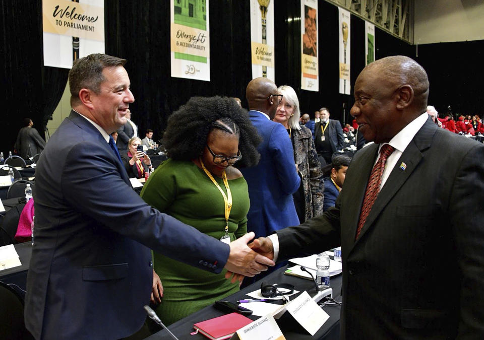 In this photo provided by the South African Government Communication and Information System, (GCIS), South African Président Cyril Ramaphosa, right, greets opposition Democratic Alliance (DA) leader, John Steenhuisen, left, at the first sitting of Parliament since elections, in Cape Town, South Africa, Friday, June 14, 2024. In a country where racial segregation was once brutally enforced, South Africa's new coalition government has brought a Black president and a white opposition leader together in what is on the face of it a picture of unity. (South African GCIS via AP)