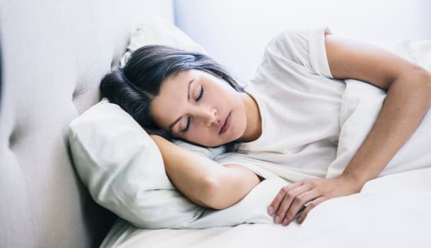 woman eyes closed laying in bed