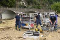 Volunteers dismantle a drinking water treatment plant in order to rebuild it on higher ground in Schuld, Germany, Thursday July 22, 2021. More rain is forecast for the region over the coming weekend. In the flood disaster area of Erftstadt-Blessem, some residents are being allowed back into their homes to clear debris after heavy rains caused devastating floods. (Thomas Frey/dpa via AP)