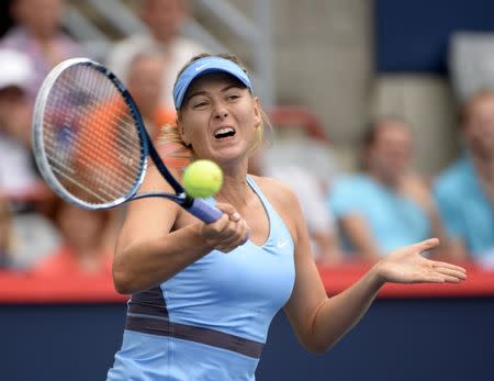 Aug 7, 2014; Montreal, Quebec, Canada; Maria Sharapova (RUS) hits a forehand against Carla Suarez Navarro (ESP) on day four of the Rogers Cup tennis tournament at Uniprix Stadium. Mandatory Credit: Eric Bolte-USA TODAY Sports