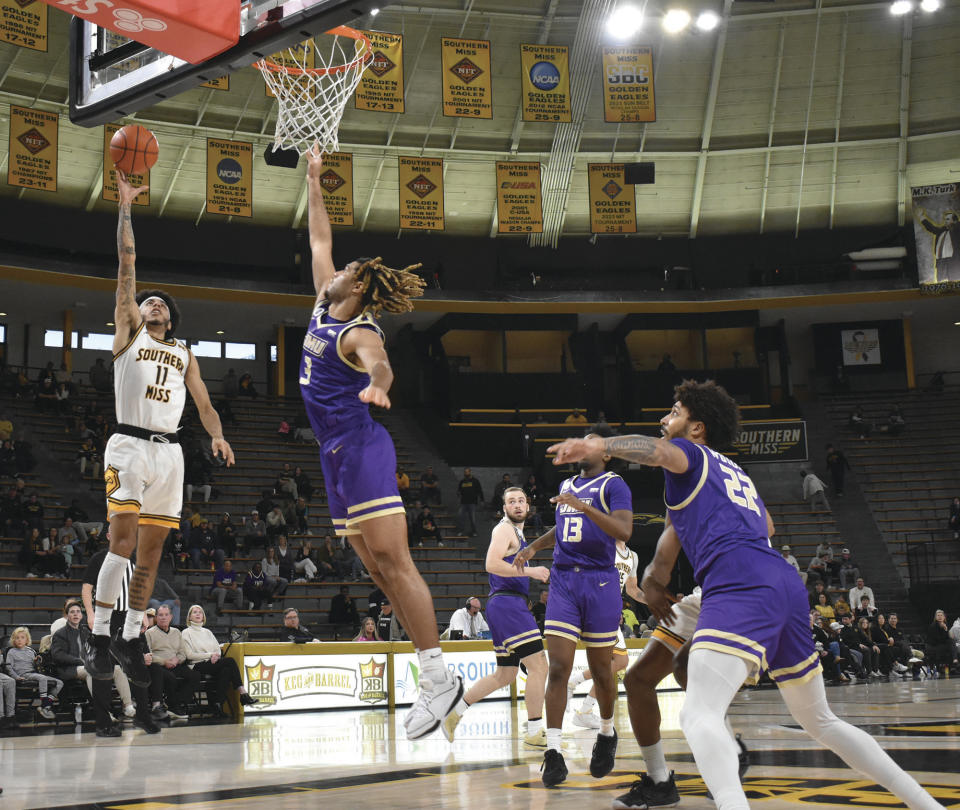 Southern Mississippi point guard Andre Curbelo (11) shoots a layup over James Madison Power Forward T.J. Bickerstaff (3) during the second half of an NCAA college basketball game Saturday, Jan. 6, 2024, in Hattiesburg, Miss. (Aimee Cronan/The Gazebo Gazette via AP)