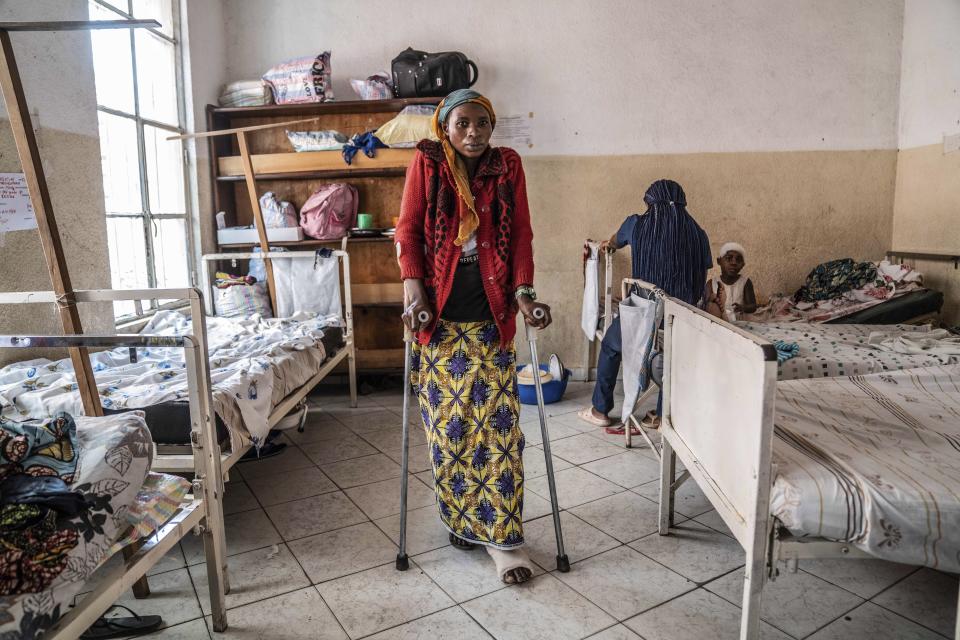 A woman who was wounded in ongoing fighting between M-23 rebel forces and Congolese forces in the Sake region West of Goma, eastern Congo, stands on crutches by her hospital bed in Goma, Tuesday, Feb. 13, 2024. In recent days, main roads around Goma and Sake, routes that are crucial for the movement of civilians, goods, and humanitarian aid, have become impassable due to intensified fighting, further restricting access to essential services and supplies said humanitarian aid organisation, Mercy Corps. (AP Photo/Moses Sawasawa)