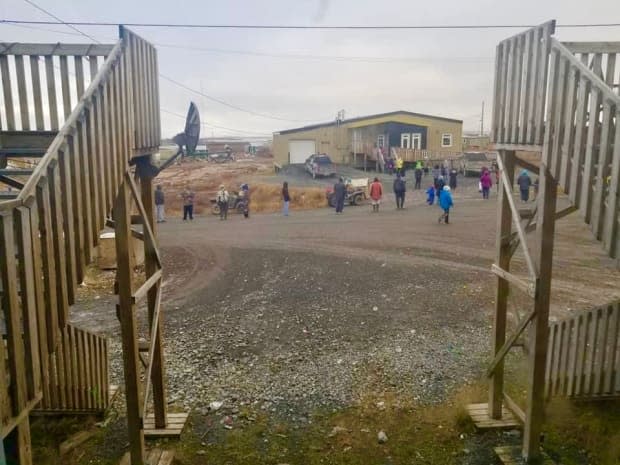 Kugluktuk residents line up in front of the Kitikmeot Inuit Association office, which is offering gift certificates to vaccinated residents of this community of about 1,500. The hamlet reported its first case of COVID-19 on Sept. 21.  (Submitted by Ross Taptuna - image credit)