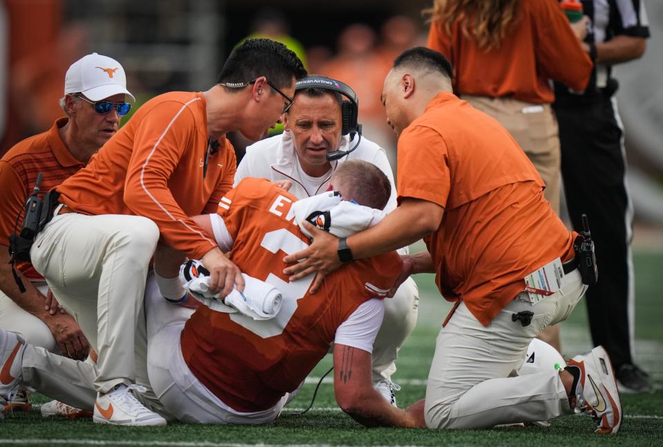 Longhorns coach Steve Sarkisian talks to quarterback Quinn Ewers as trainers tend to Ewers in the second quarter of Saturday's game.