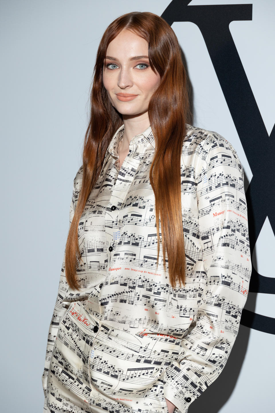 Sophie Turner posing in a unique music-sheet patterned outfit