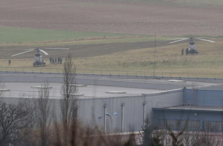 French security forces stand next to helicopters in front of a building in Dammartin-en-Goele