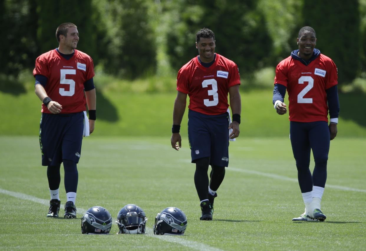 Seattle Seahawks quarterback Russell Wilson, right, walks off the field with backups Trevone Boykin (2) and Jake Heaps (5) following NFL football practice, Friday, June 2, 2017, in Renton, Wash. (AP Photo/Ted S. Warren)