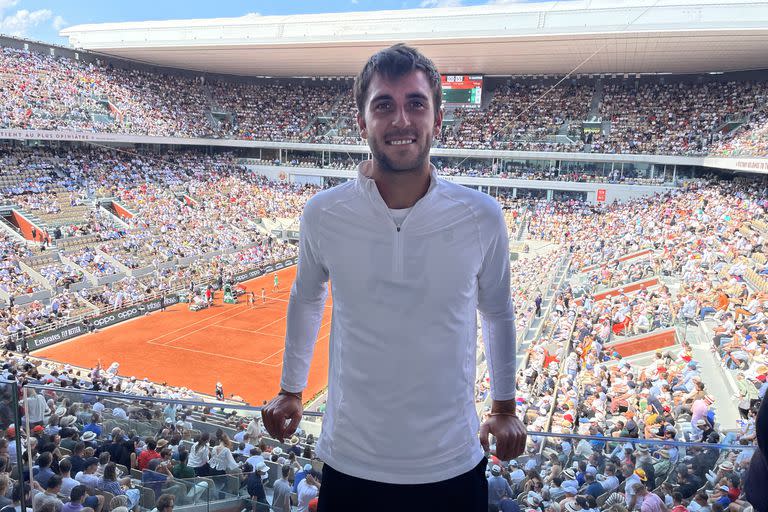 Tomás Etcheverry, con LA NACION, en el lugar de los sueños; de fondo, el estadio Philippe Chatrier a pleno mientras juegan Djokovic y Khanachov