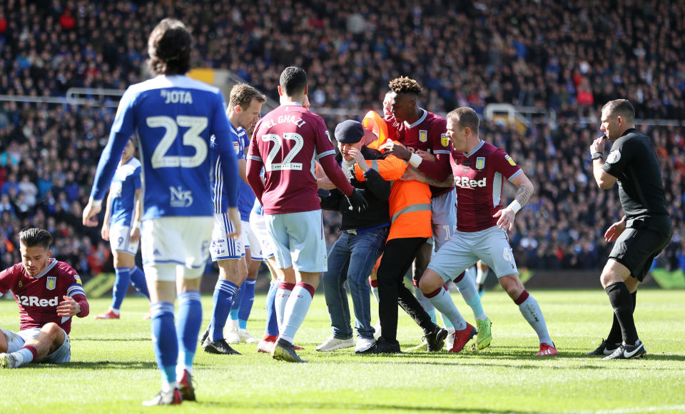 Birmingham City fan Paul Mitchell is restrained after attacking Jack Grealish. (Credit: PA)
