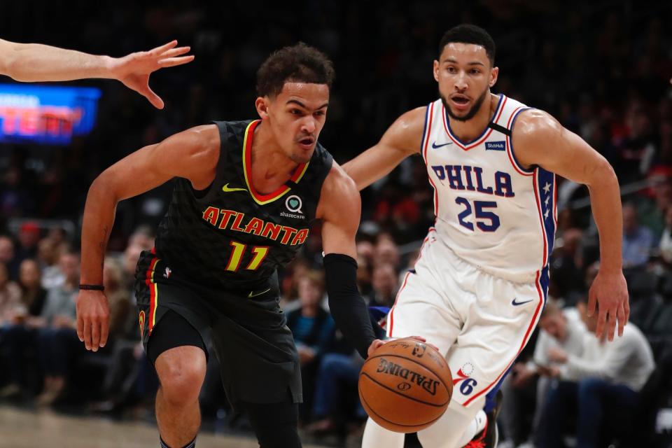 Atlanta Hawks guard Trae Young, left, drives past Philadelphia 76ers guard Ben Simmons durng a Jan. 30, 2020 game.