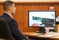 Former New England Patriots player Aaron Hernandez listens as a photo of a small handgun found in a wooded area near the crime scene was displayed during his murder trial at the Bristol County Superior Court in Fall River, Massachusetts February 13, 2015. REUTERS/Aram Boghosian/Pool (UNITED STATES - Tags: CRIME LAW SPORT FOOTBALL)