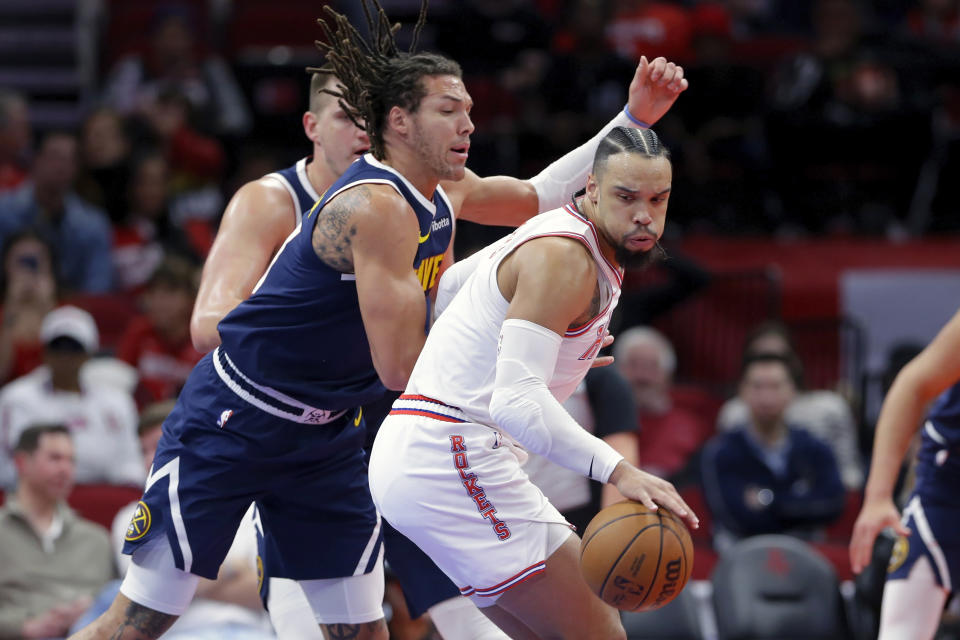 Houston Rockets forward Dillon Brooks, right, spins in front of Denver Nuggets forward Aaron Gordon, left, during the first half of an NBA basketball In-Season Tournament game Friday, Nov. 24, 2023, in Houston. (AP Photo/Michael Wyke)