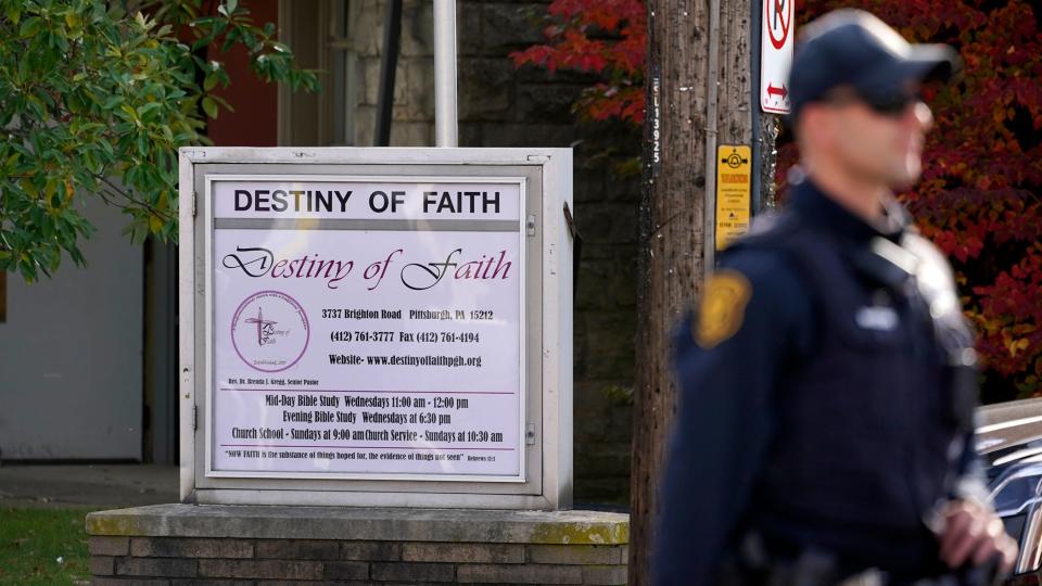 A Pittsburgh Police officer stands outside the Destiny of Faith Church in Pittsburgh, Friday Oct. 28, 2022, where a shooting while a funeral was being held, left six people wounded, including one person who was hospitalized in critical condition.
