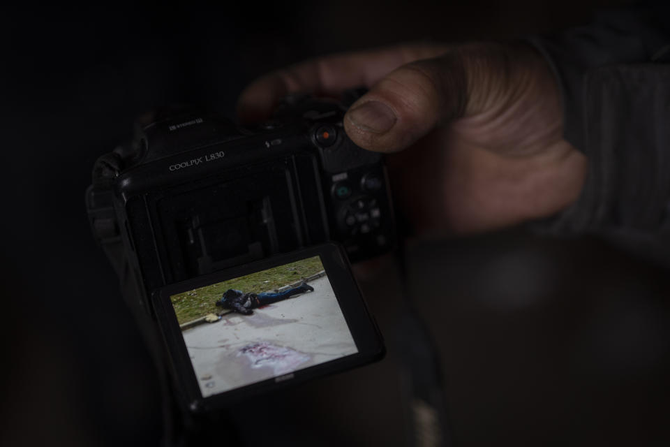 A Ukrainian man displays a picture dated March 1, showing the body of 50-year-old construction worker Kostiantyn Maltev in Kherson, Ukraine, on Sunday, Nov. 20, 2022. About two dozen civilian volunteers of the Ukrainian Territorial Defense Forces were killed by Russian troops in the southern city before they the town and held it for eight months before retreating in November. Since the attack, relatives have been asking questions about happened to their loved ones, wanting to know details of their deaths.(AP Photo/Bernat Armangue)