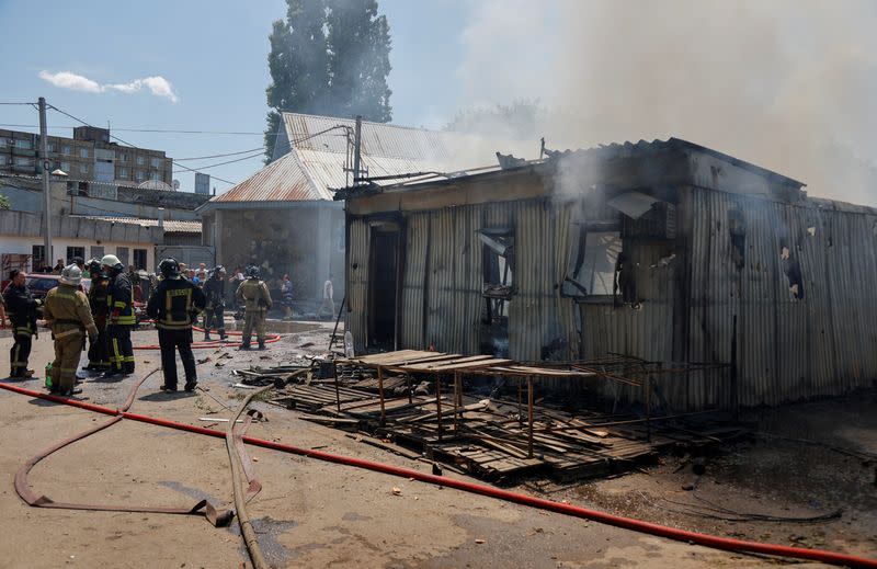 Firefighters extinguish a fire at a market following recent shelling in Donetsk