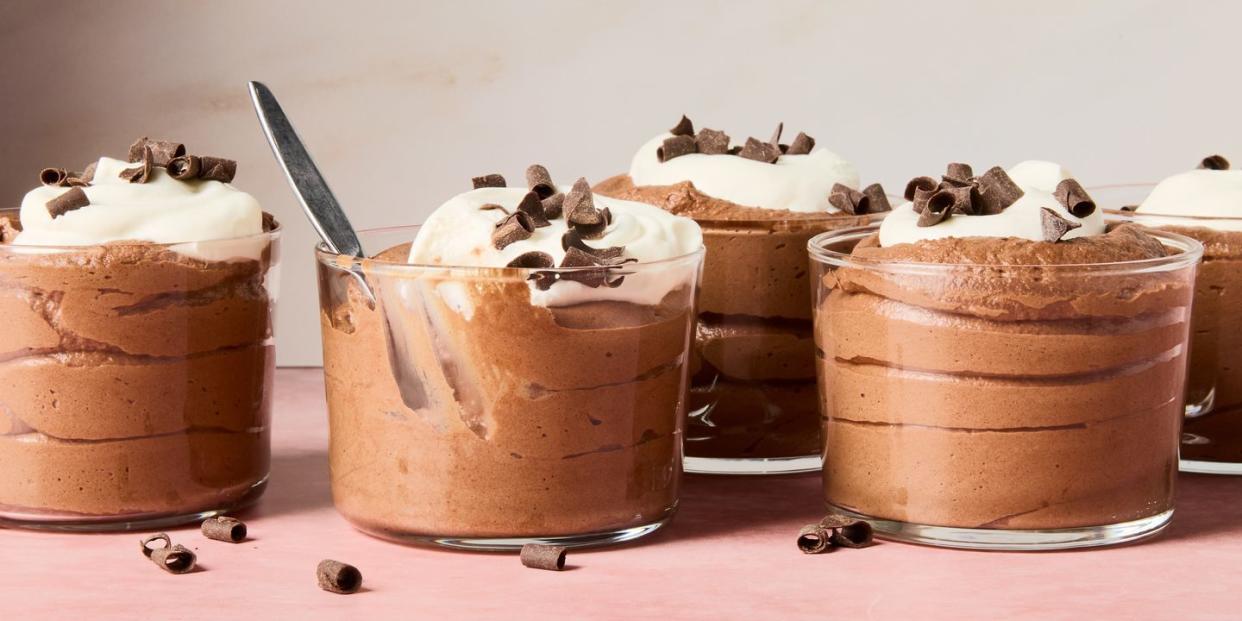 chocolate mousse in containers topped with whipped cream and chocolate shavings