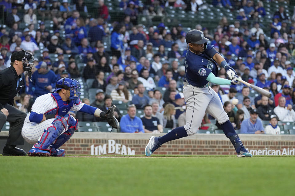 Seattle Mariners' Julio Rodriguez, right, strikes out swinging on a foul tip during the first inning of a baseball game against the Chicago Cubs in Chicago, Monday, April 10, 2023. (AP Photo/Nam Y. Huh)