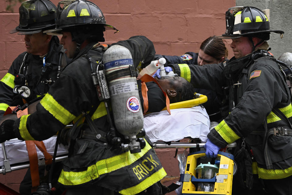 Emergency personnel use a manual resuscitator on a fire victim during a high rise fire on East 181 Street, Sunday, Jan. 9, 2022, in the Bronx borough of New York. (AP Photo/Lloyd Mitchell)