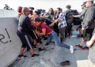 Varias personas intentan retener a otros manifestantes que se acercaban al lugar en el que se encontraba el conductor. (Foto: Eric Miller / Reuters).