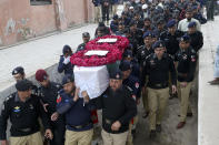 Police officers carry the casket of a fellow police officer, a victim of Monday's suicide bombing, for his funeral in Peshawar, Pakistan, Feb. 2, 2023. A suicide bomber who killed 101 people at a mosque in northwest Pakistan this week had disguised himself in a police uniform and did not raise suspicion among guards, the provincial police chief said on Thursday. (AP Photo/Muhammad Sajjad)